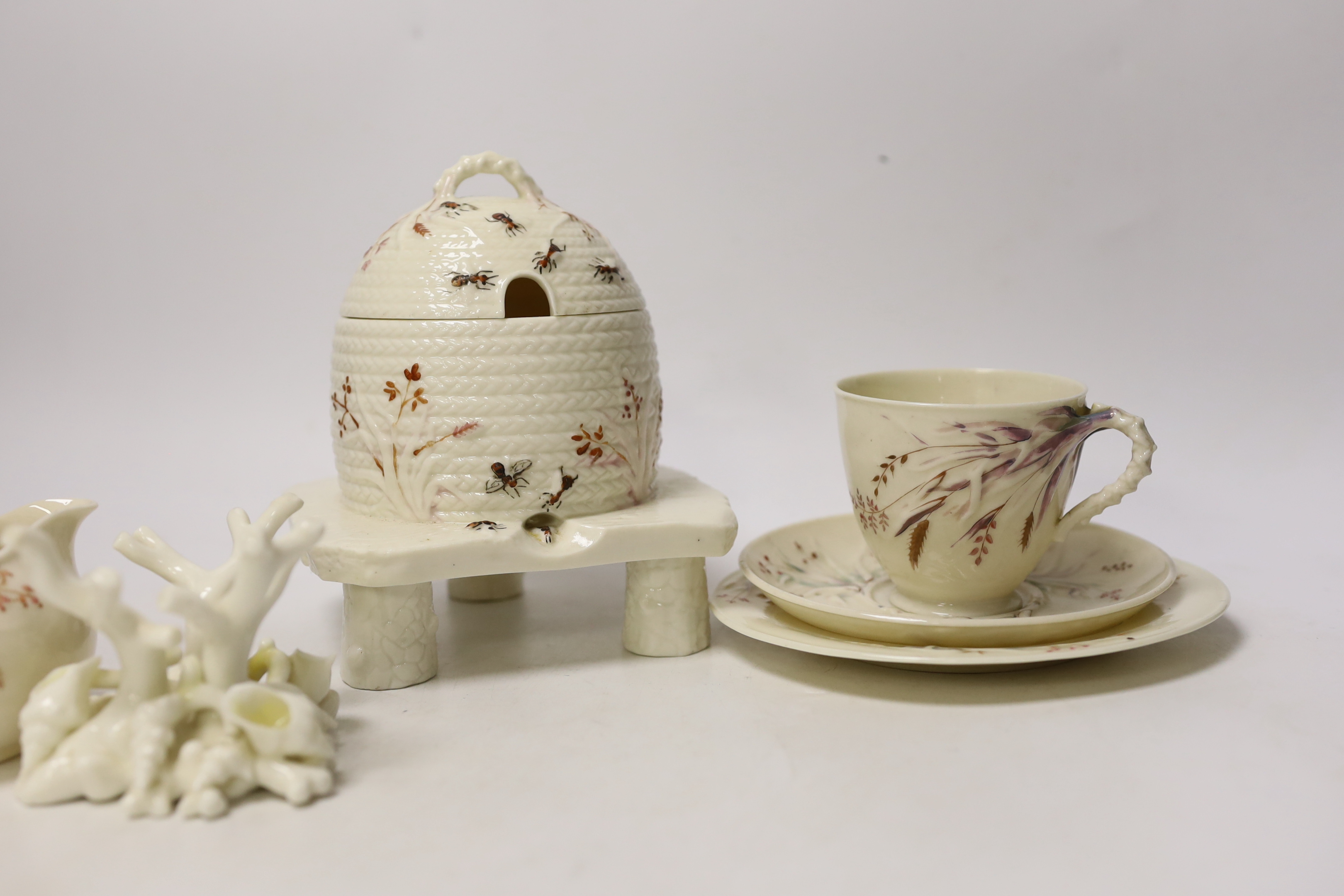 A small quantity of 1st and 2nd period Belleek including a ‘frog’ paperweight and a ‘beehive’ honey jar together with a related reference book by Marion Langham
